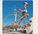 Escultura de uma bicicleta antiga com uma roda grande